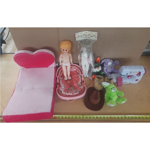 Collection of toys, including dolls, plush animals, a heart-shaped doll bed, and a toy sewing machin