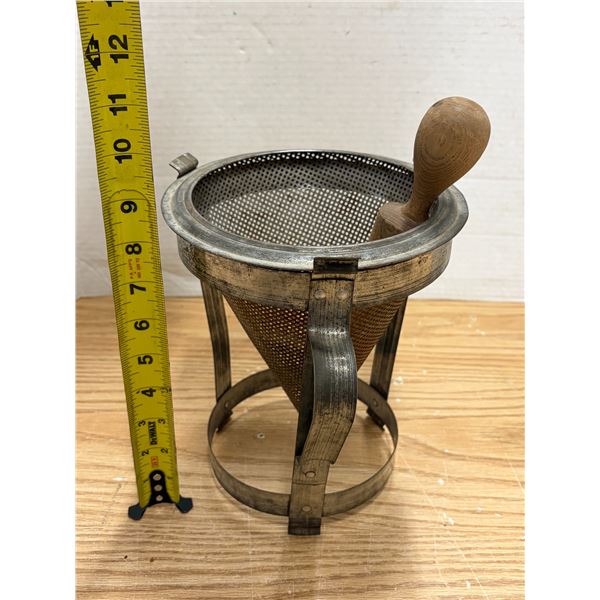 Vintage mid-20th-century metal cone sieve and tripod stand set featuring a fine mesh strainer, match