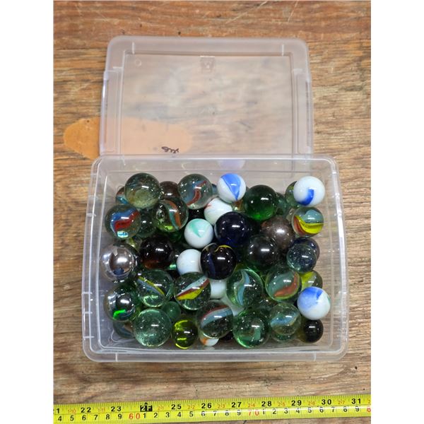 Plastic bin full of various large marbles