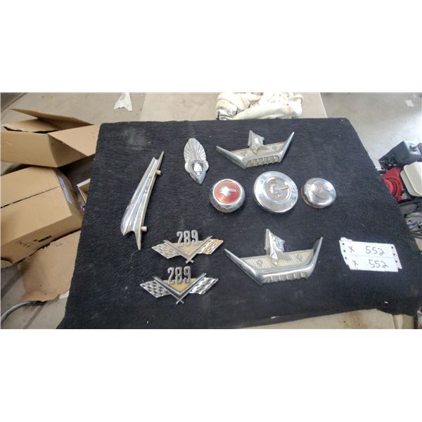 Vintage Automotive Emblems Including Ford 289 V8, Fairlane Trim, Plymouth, and Pontiac