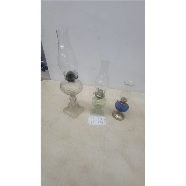Three Oil Lamps: Clear Glass Pedestal Lamp, Green Glass Pedestal Lamp, and Blue Glass Lamp