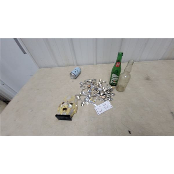 Assorted Collectibles: Stone Mask on Stand, 7UP Bottle, Yeti Can, and Souvenir Spoons