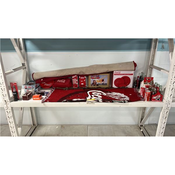 SHELF OF ASSORTED COCA-COLA COLLECTIBLES: THROW BLANKET, AREA RUG, MELAMINE DINNERWARE SET & MORE