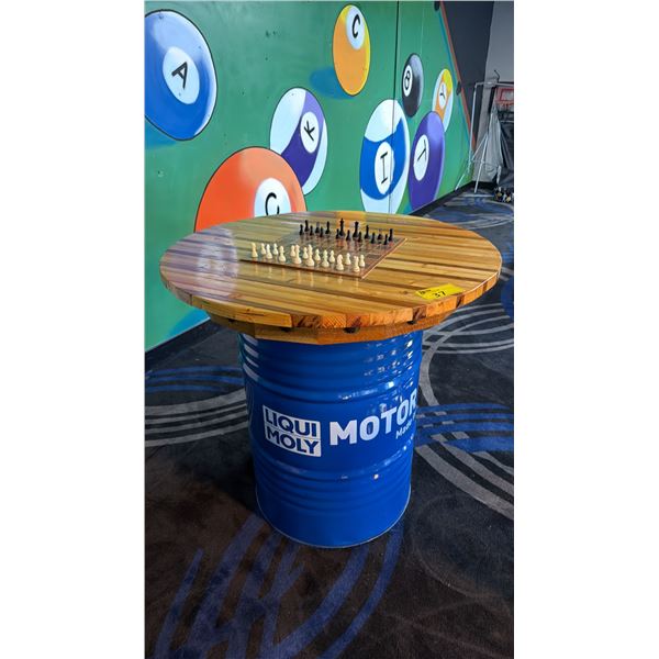 3FT DIAMETER WOODEN TABLE TOP ON BLUE 50 GALLON OIL DRUM W/CHESS SET - APPROX. 3FT HIGH