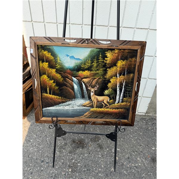 vintage 1970s mid-century black velvet landscape painting featuring a deer and waterfall in a carved