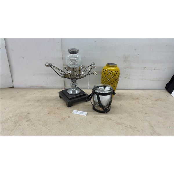 Three Decorative Solar Lanterns Including Metal and Wood Tabletop, Yellow Ceramic, and Glass Jar