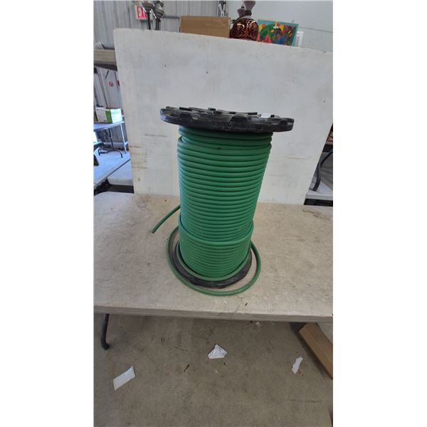 Large Spool of Green Hose, 3/4” x 325' Drip Irrigation Hose, and Black Plastic Spool