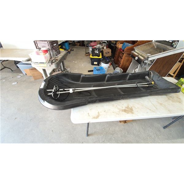 Black Plastic Sled with Two Ski Poles and Tow Rope