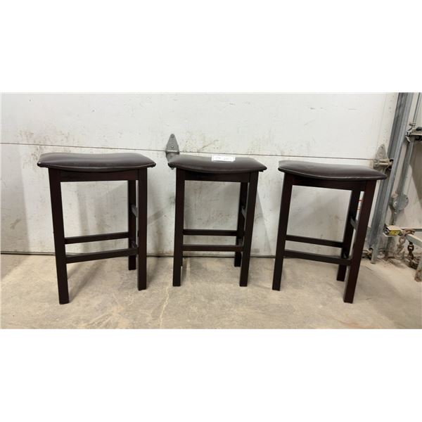 Three Dark Brown Wooden Backless Bar Stools with Padded Faux Leather Saddle Seats