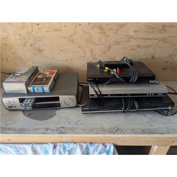(3) DVD Players, (2) VHS Player w/ (2) VHS Movies – Not Tested