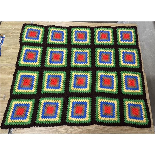Handmade crochet throw blanket featuring a classic grid of colorful granny squares joined with a dar