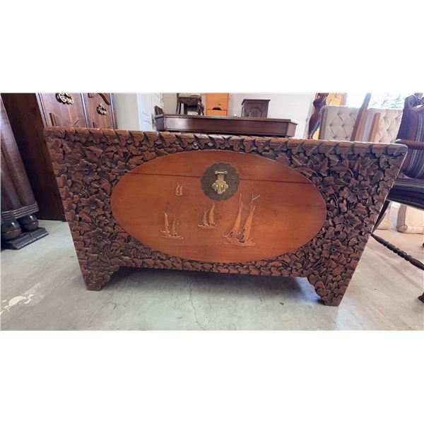Chinese Rectangular hand-carved wooden chest featuring detailed floral carvings across the exterior 