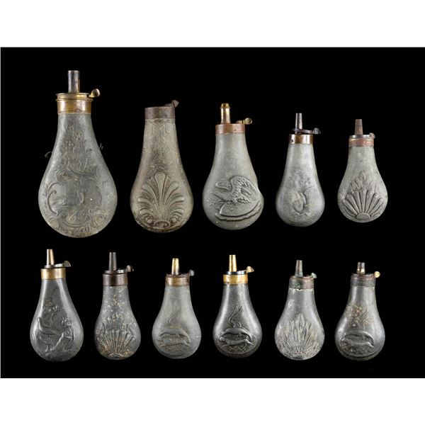 GROUP OF 11 ZINC EMBOSSED POWDER FLASKS.
