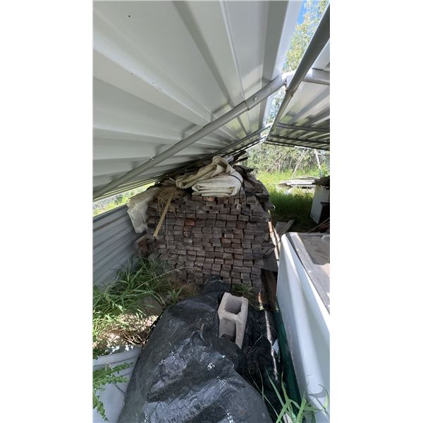 Stack Of Reclaimed Lumber Stored Under Metal Roof