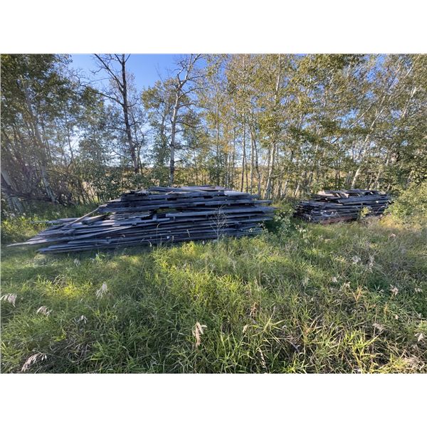 Two Large Piles of Weathered Wood Planks
