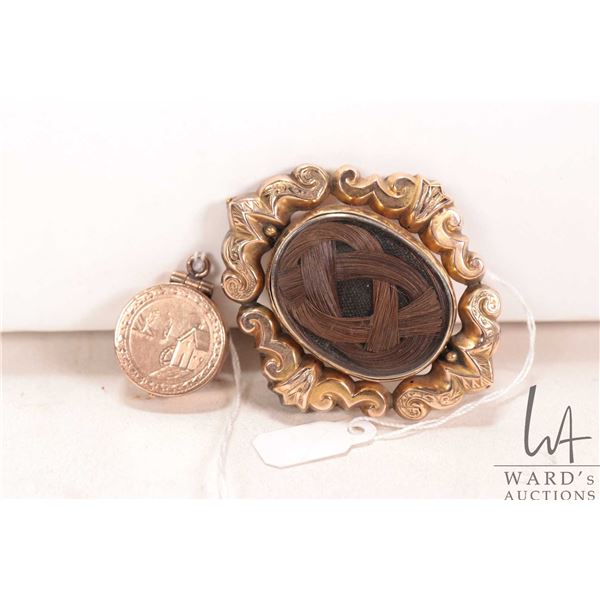 Two pieces of antique Victorian mourning jewellery including rolled gold brooch with braided dark ha