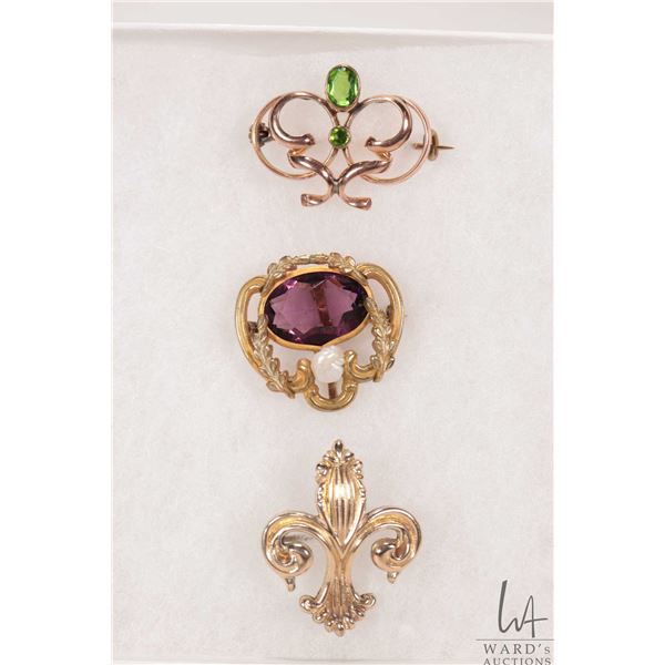 Three antique brooches including tested 14kt yellow gold set with peridot like green gemstones, and 