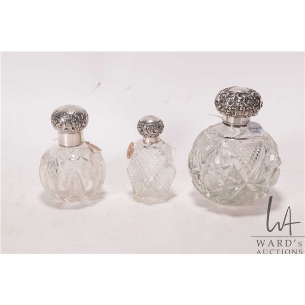 Three antique repousse silver topped perfumes including large cut glass with original crystal stoppe