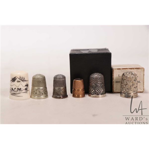 Six collectible thimbles including Inuit carved scrimshaw featuring a dog sled team, two boxed sterl