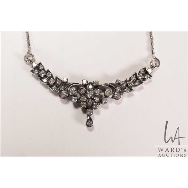 Antique/ vintage silver pendant set with diamond gemstones and attached to a silver like neck chain