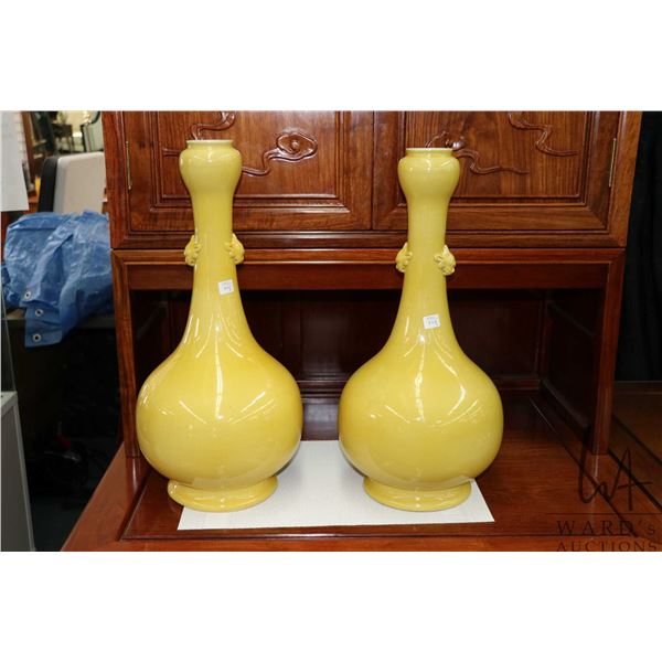 Pair of large Chinese yellow ground garlic bulb vases with with molded mask decoration, each 22" in 