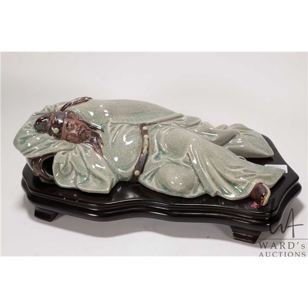 Glazed clay figure of a sleeping Chinese scholar on wooden plinth 14" in length