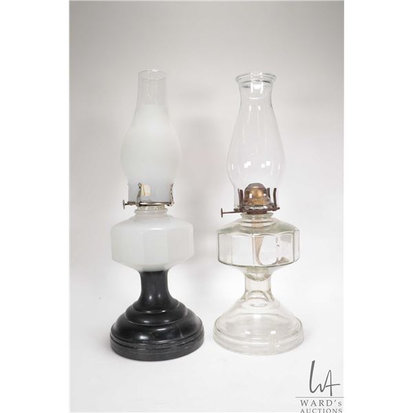 Two vintage oil lamps including colourless and milk glass, both with chimneys