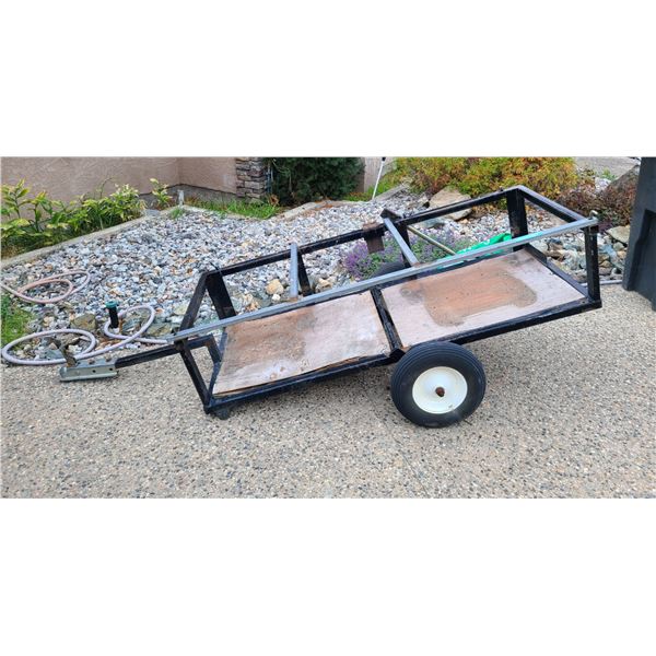 Single-axle utility trailer with a black metal frame
