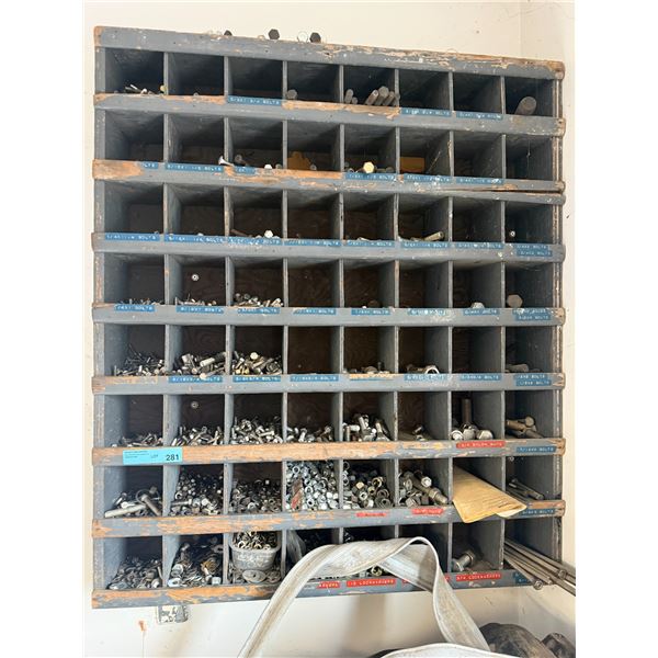 Wall-mounted wooden pigeonhole storage bin filled with an assortment of bolts, nuts, washers, etc