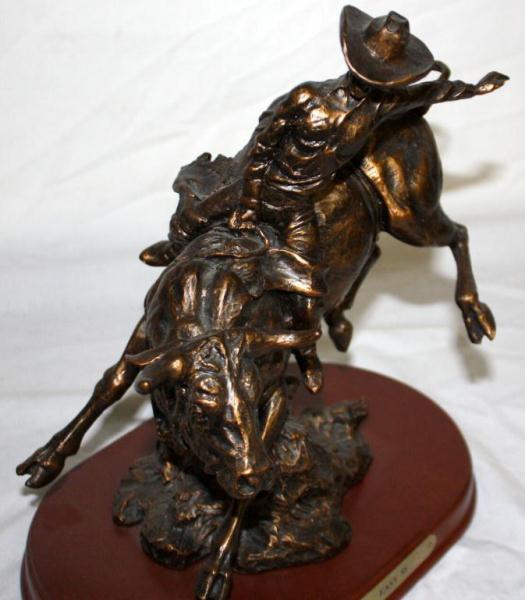 Bronze Statue Of A Cowboy Riding A Bull