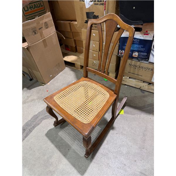 vintage or antique wooden rocking chair with a woven cane seat