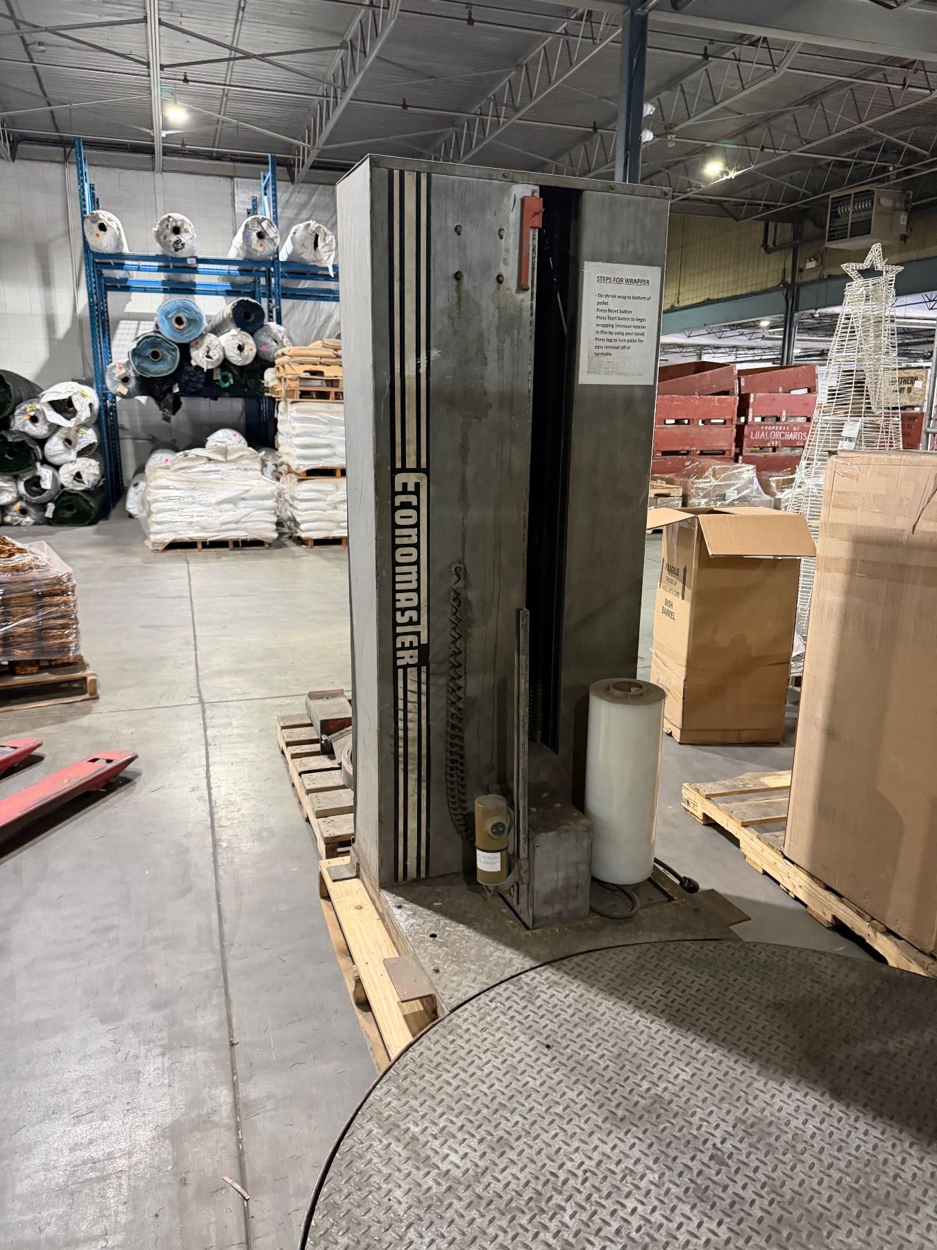 Economaster turntable stretch wrapper, which is an industrial machine ...