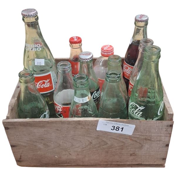 Collection of vintage Coca-Cola bottles in wood box
