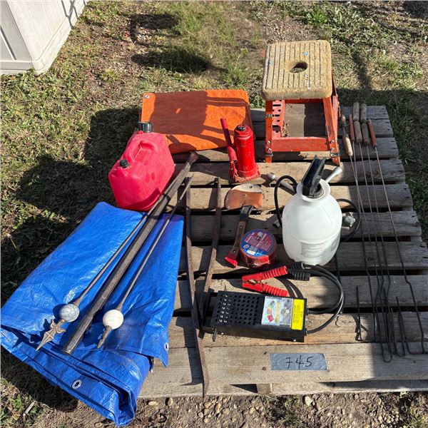 Pallet with weed sprayer, battery tester, bottle jack, axe, work chair, 2 tarps, pry bars, camp fire
