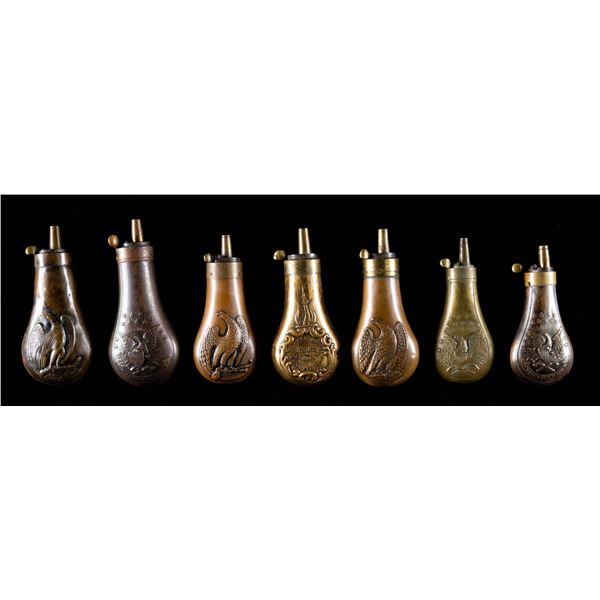 GROUP OF 7 "EAGLE" EMBOSSED POWDER FLASKS.