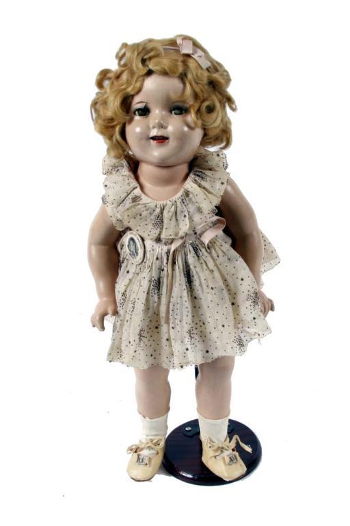 Original Shirley Temple Doll by Ideal in composition, with original dress, shoes, and button. Some f