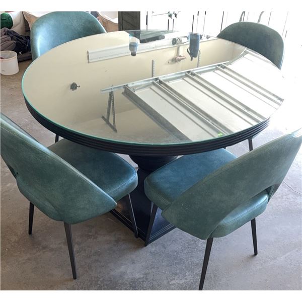 Round Glass Top Dining Table With Black Pedestal Base And Four Teal Upholstered Chairs