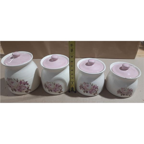Set of four ceramic or porcelain kitchen storage canisters in graduating sizes with white bodies, pi