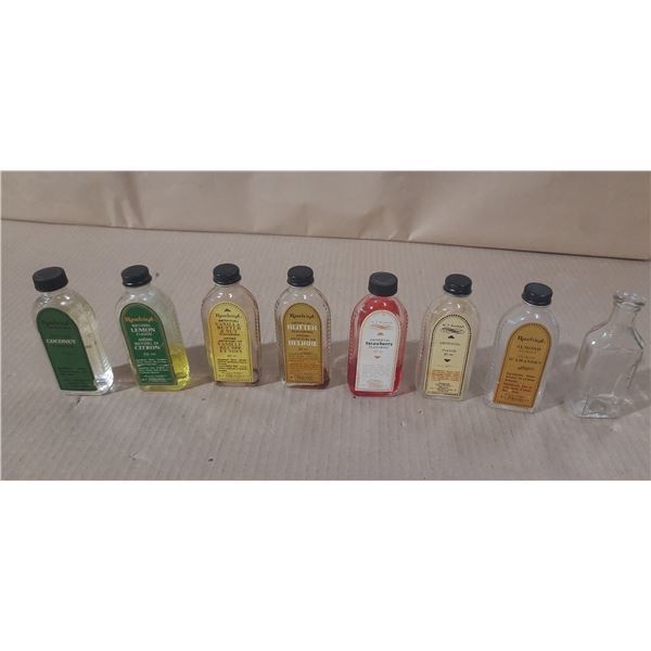 Collection of vintage glass bottles, mostly labeled as W.T. Rawleigh Company extract and flavoring b