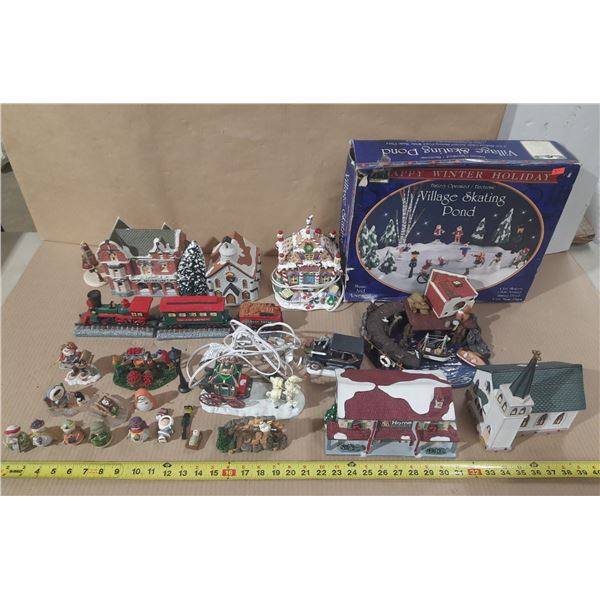 Collection of miniature Christmas village buildings, figurines, a train set, and a "Village Skating 
