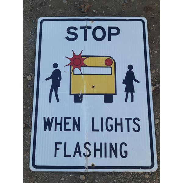Traffic sign that instructs drivers to stop and not pass when school bus warning lights are flashing