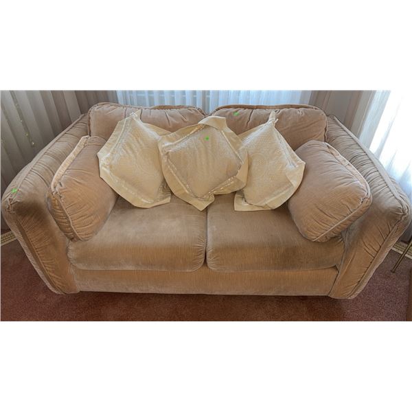 Beige Upholstered Loveseat With Four Cream Patterned Throw Pillows