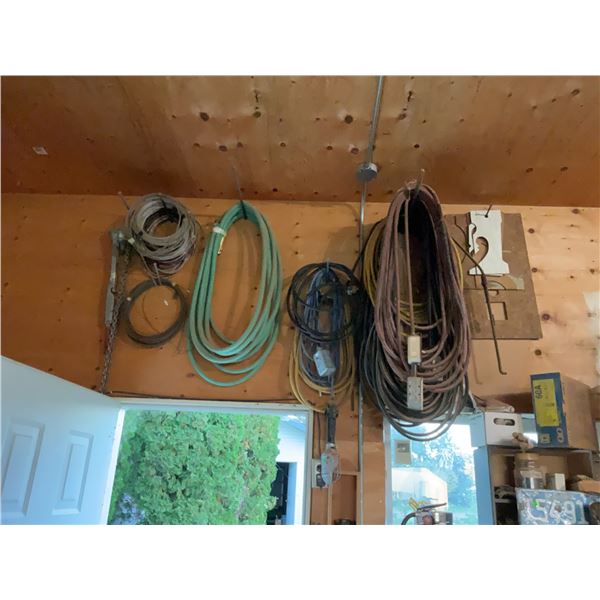 Extension Cords, Electrical Cables, Hose, and Chain Hanging From Wall