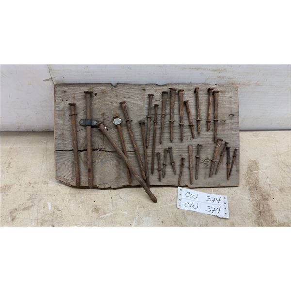 Collection of Antique Hand-Forged Iron Nails and Spikes on Weathered Wood Display Board, 9 × 17”