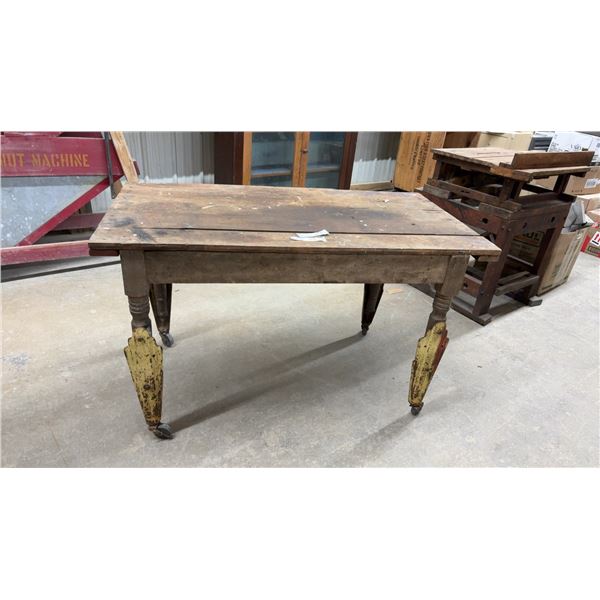 Antique Wooden Table with Turned Legs and Yellow-Painted Metal Leg Extenders on Casters