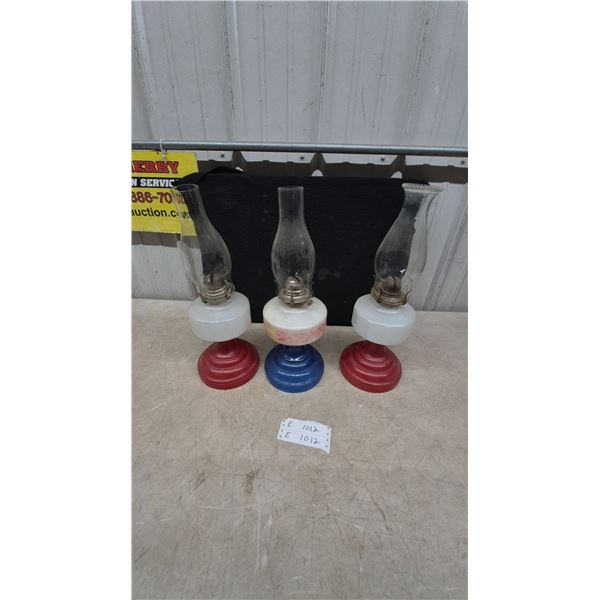 Three Oil Lamps: Two Red Base and White Font, One Blue Base and Floral White Font