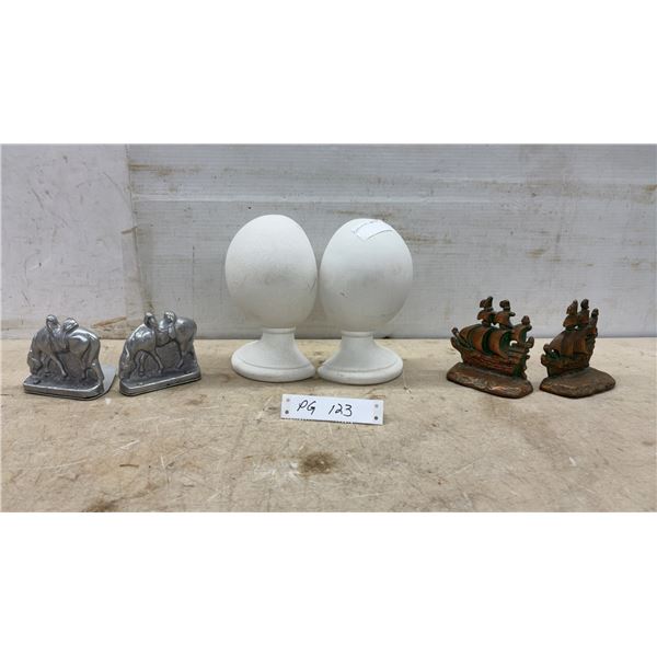 Three Pairs of Bookends: Silver Horse and Rider, Bronze Sailing Ship, and Ceramic Egg on Pedestal
