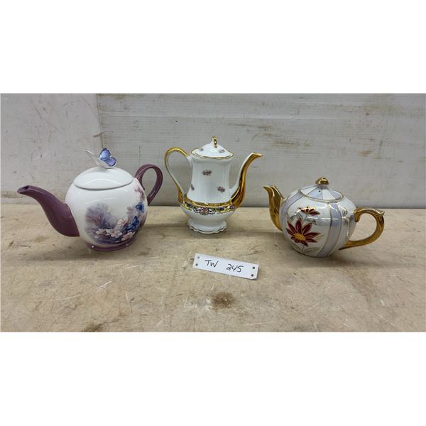Three Decorative Porcelain Teapots with Floral Motifs, Butterfly Finial, and Gold Gilding