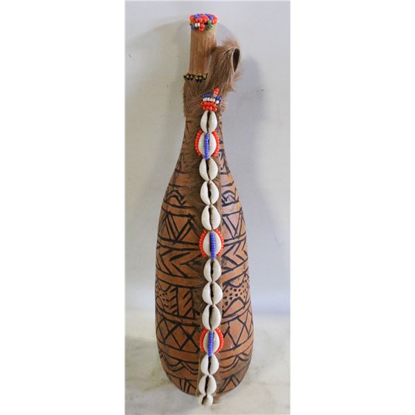 GOURD VESSEL DECORATED WITH FUR AND SHELLS.