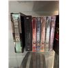 Image 2 : Wood and Glass Shelf Unit With DVDs, Remote Controls, Plush Tiger, and Decor Items